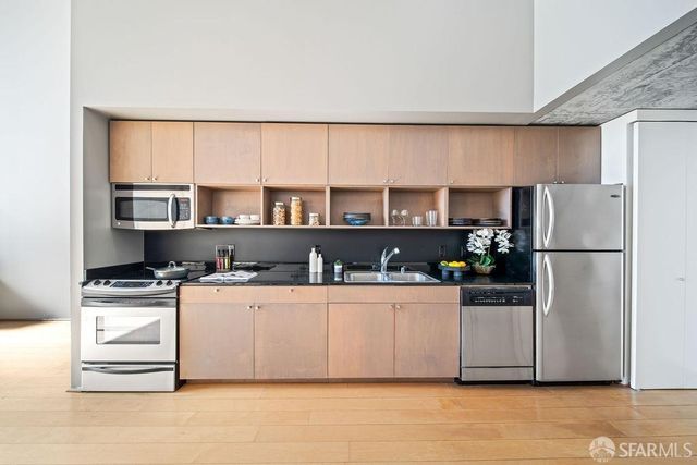 a kitchen with stainless steel appliances a refrigerator and a cabinets