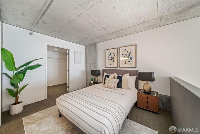 a bedroom with a large bed and a potted plant
