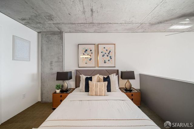 a bed room with a bed and painting on the wall