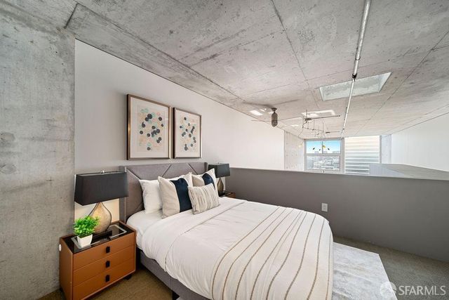 a bedroom with a bed and a painting on the wall