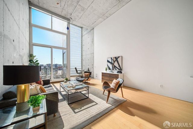 a living room with furniture a flat screen tv and a floor to ceiling window