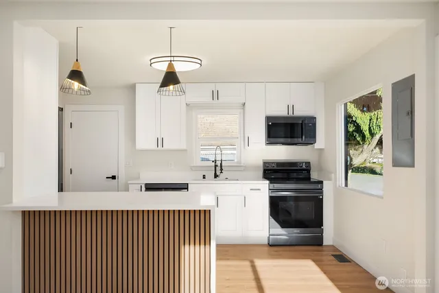 a kitchen with stainless steel appliances granite countertop a stove a sink and a microwave