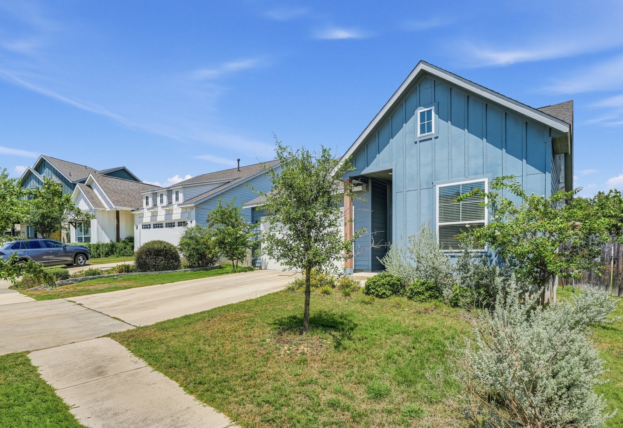 145 Brooks Ranchi Drive Kyle, TX 78640 - Photo 4 of 40 Board and batten siding creates an inviting exterior profile under clear blue skies.