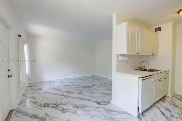 a kitchen with granite countertop a sink stove and refrigerator