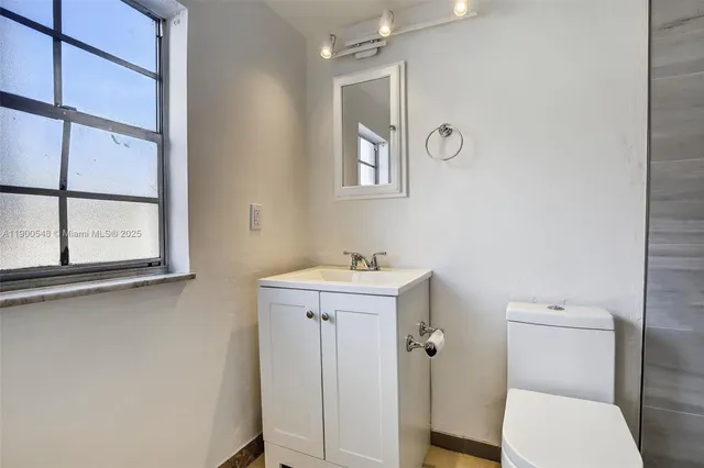 a bathroom with a toilet a sink and a window