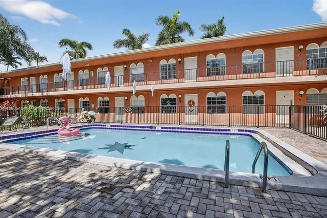 a view of a building with a swimming pool and sitting area