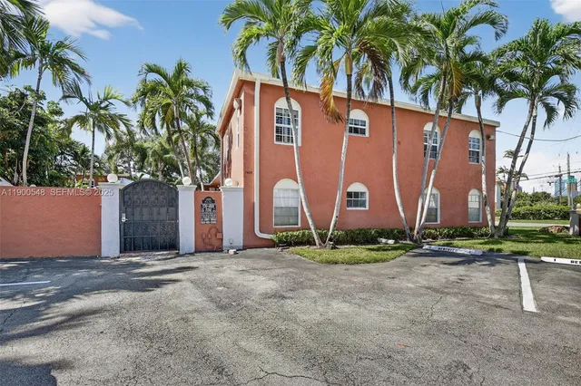 a front view of a house with a yard and palm trees