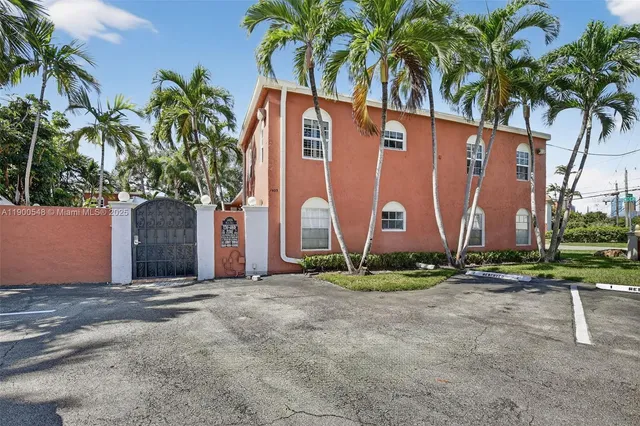 a front view of a house with a yard and palm trees