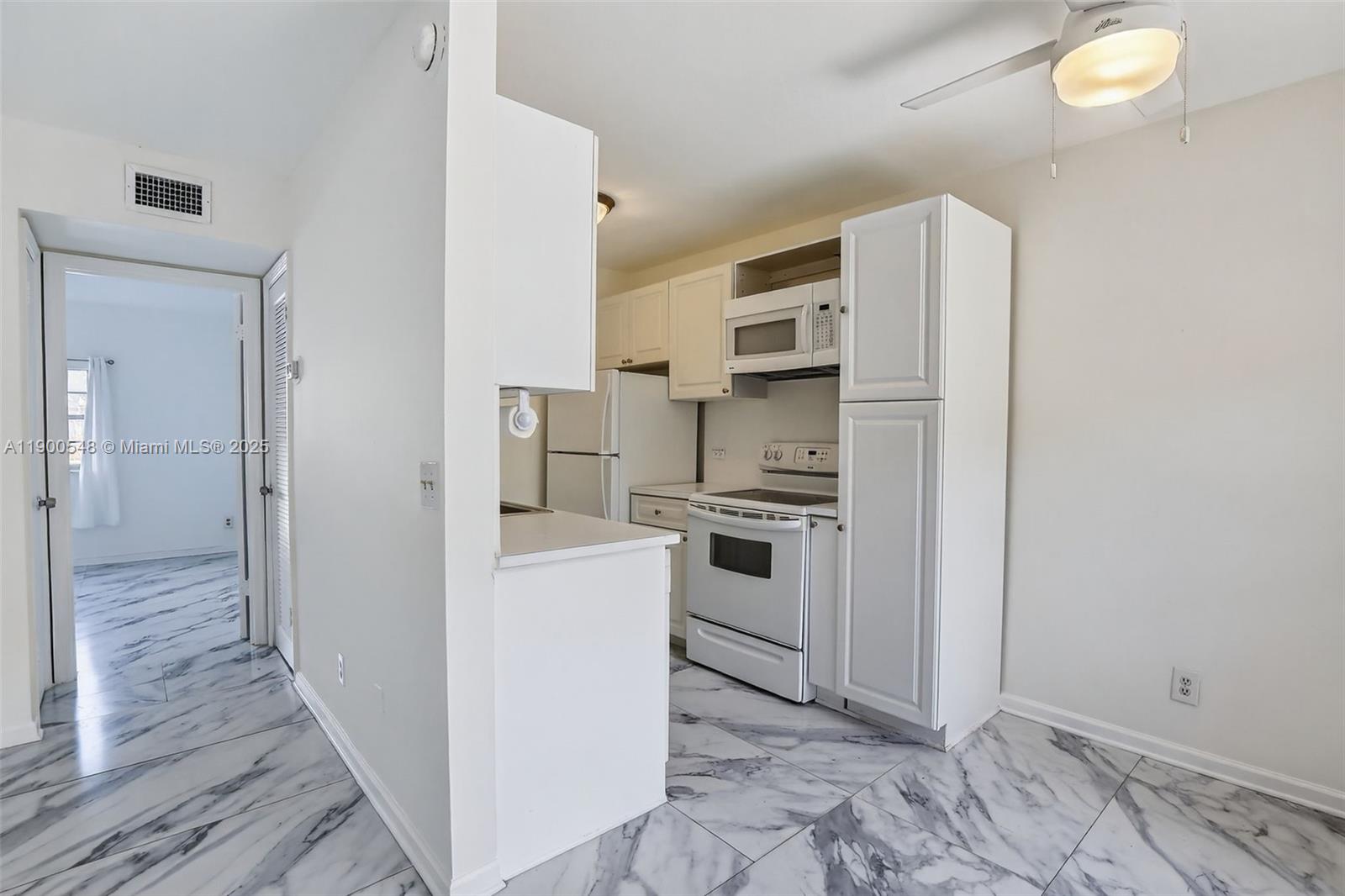1405 Miami Road, Unit 5 Fort Lauderdale, FL 33316 - Photo 9 of 25 a kitchen with white cabinets and white appliances
