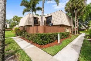 a front view of a house with a yard and potted plants