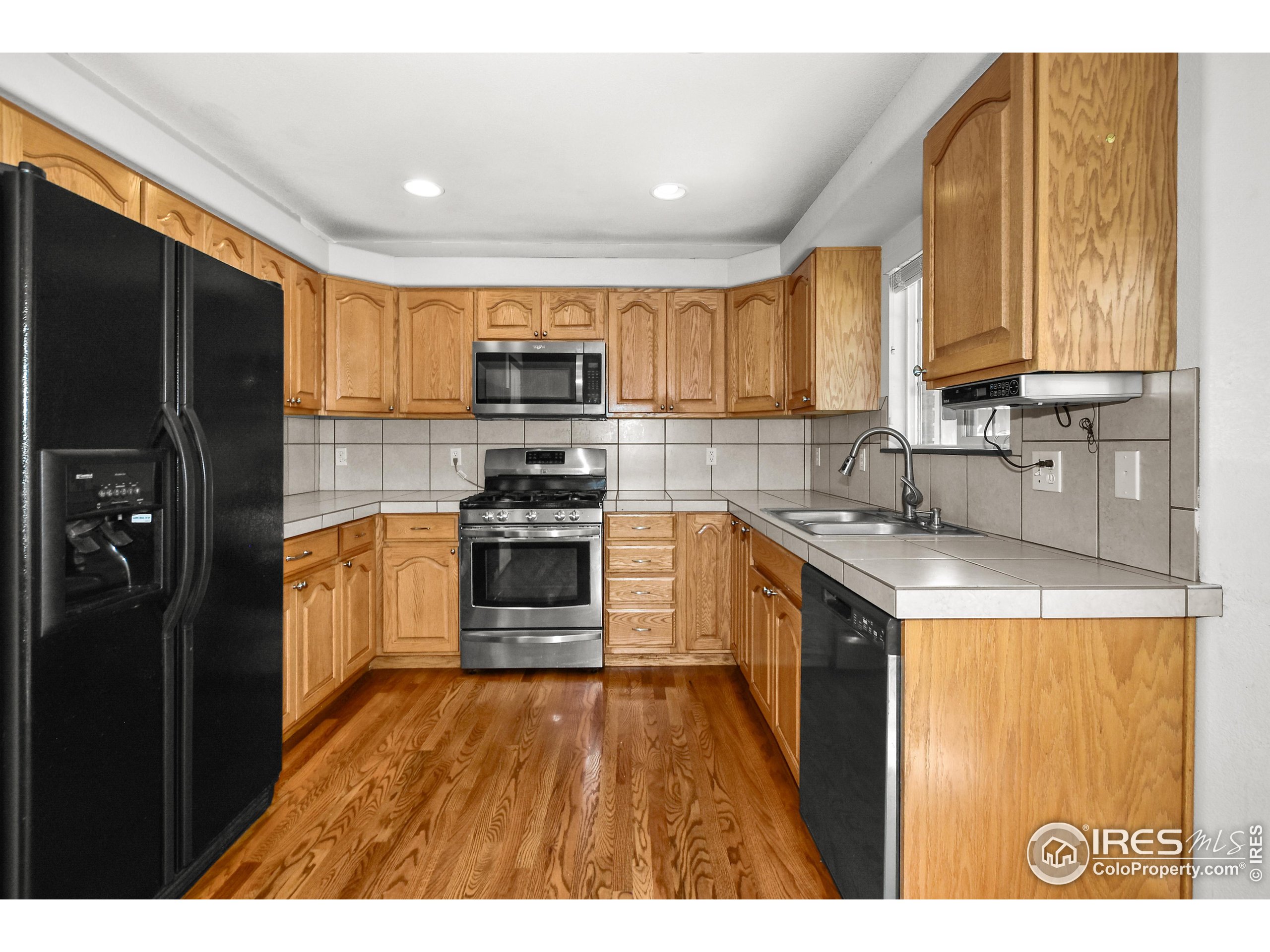 205 Timber Ridge Court Severance, CO 80550 - Photo 13 of 48 a kitchen with kitchen island granite countertop a stove top oven a sink a counter top space and cabinets