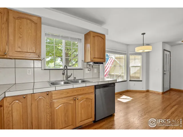 a kitchen with kitchen island granite countertop a sink cabinets and window