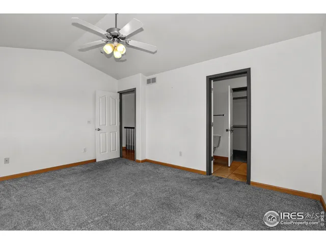 a view of an empty room with chandelier fan
