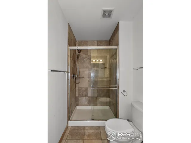 a view of an empty room with a chandelier fan