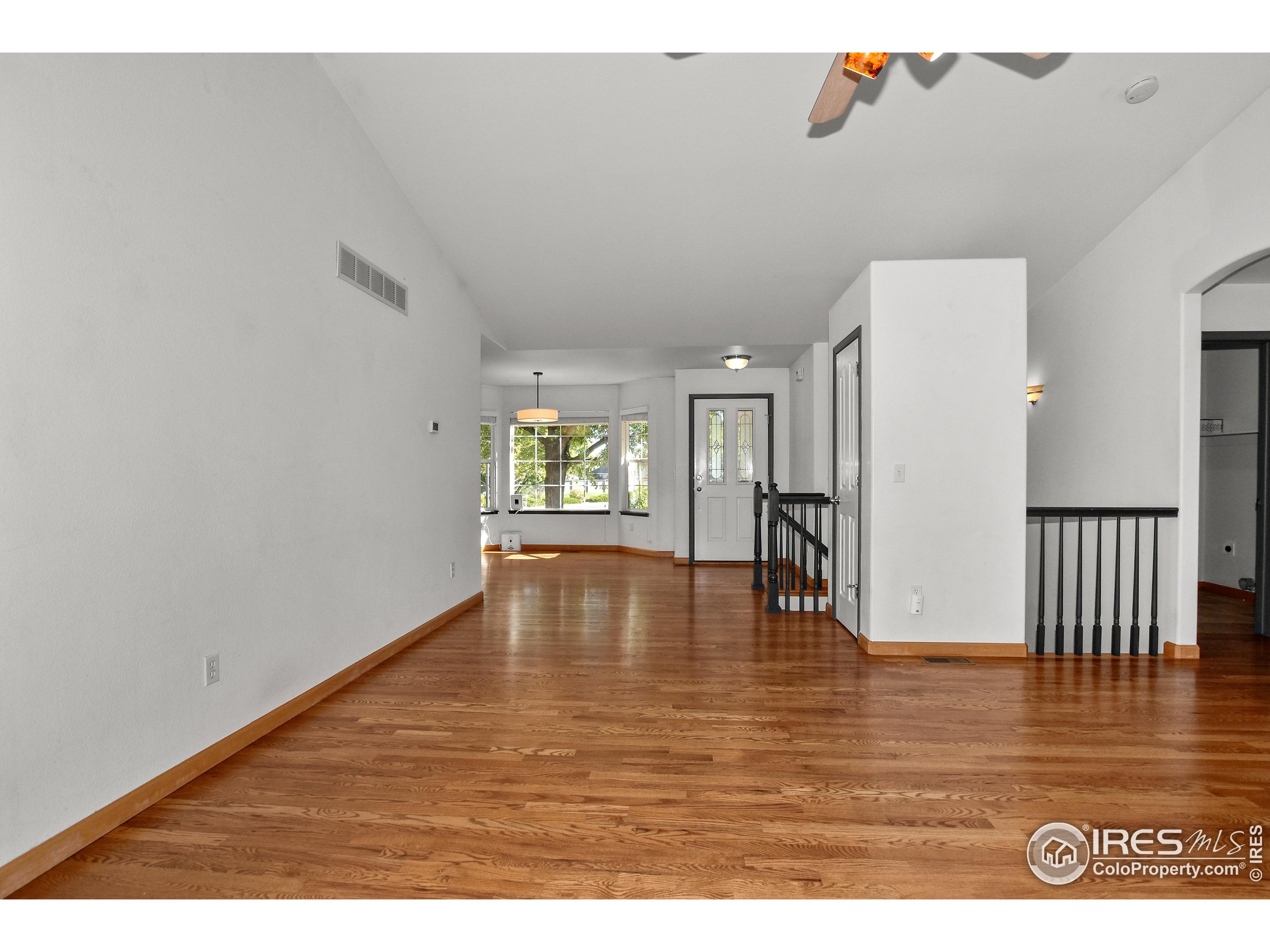 205 Timber Ridge Court Severance, CO 80550 - Photo 8 of 48 an empty room with wooden floor and windows