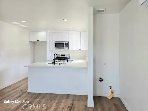 a kitchen with kitchen island a sink stainless steel appliances and cabinets