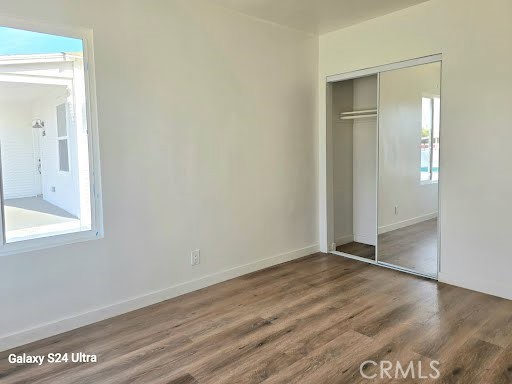 1350 East 94th Street Los Angeles, CA 90002 - Photo 10 of 15 an empty room with wooden floor mirror and windows