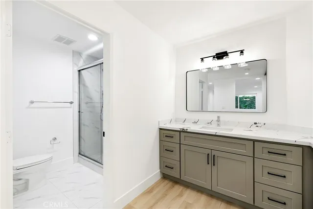 a bathroom with a double vanity sink mirror and toilet