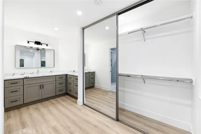a spacious bathroom with a double vanity sink a mirror and a shower