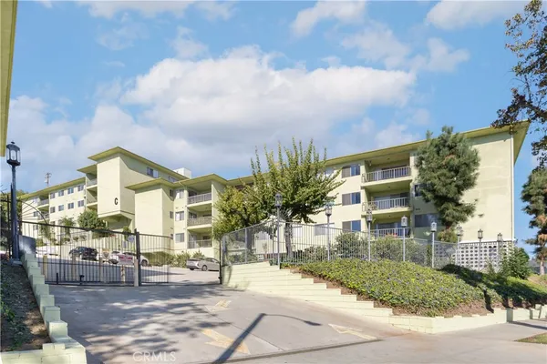 a front view of a building with street view and trees