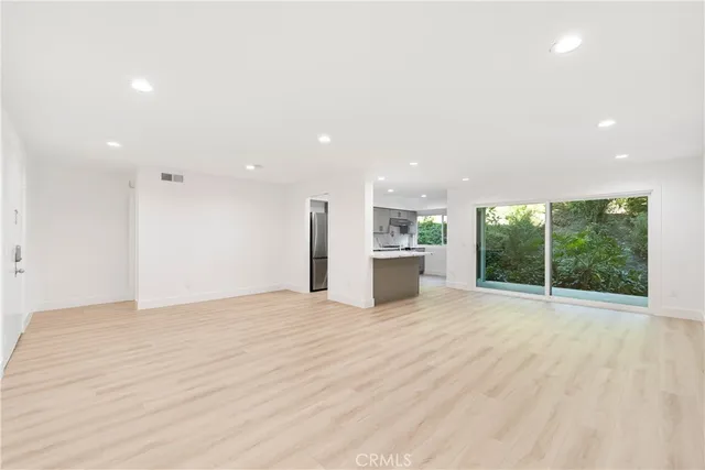 a view of an empty room with a kitchen counter top space and a sink