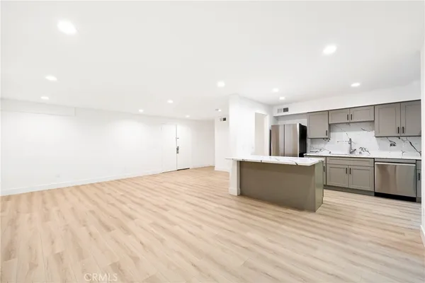 a kitchen with stainless steel appliances kitchen island granite countertop a sink and cabinets
