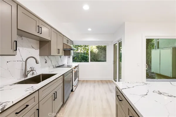a large kitchen with a sink and cabinets