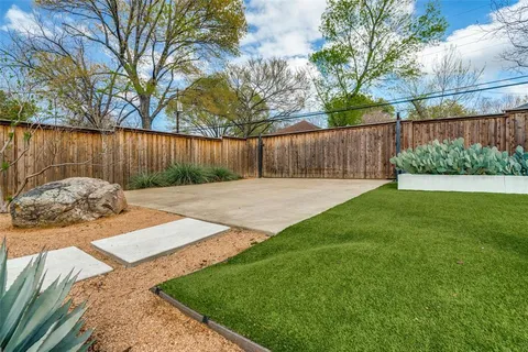 a view of a backyard with a table and chair and wooden fence