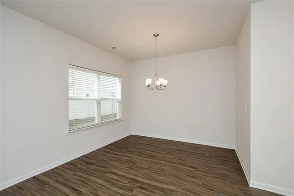 a view of a room with wooden floor and a window
