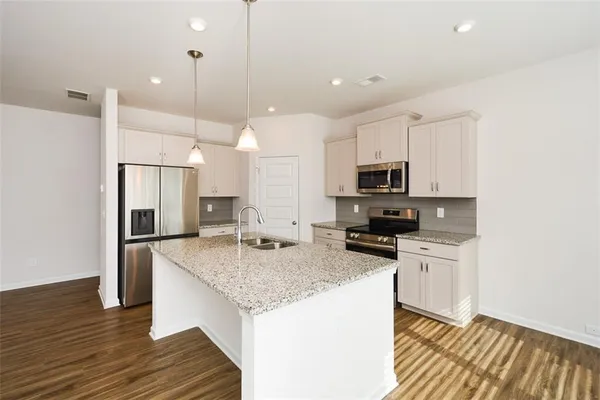 a kitchen with stainless steel appliances granite countertop refrigerator sink and stove