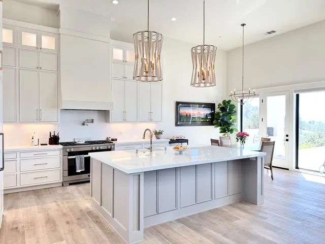 a living room with furniture kitchen area and large windows
