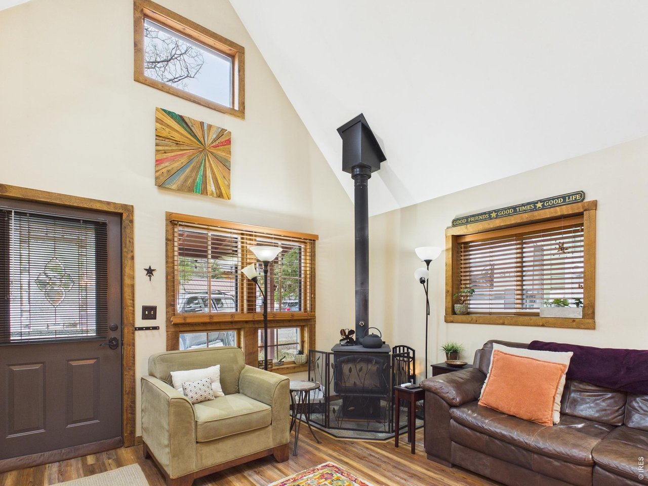 131 West Boulder Street Nederland, CO 80466 - Photo 5 of 46 Cozy living room with vaulted ceiling, wood stove, skylights, and natural light.