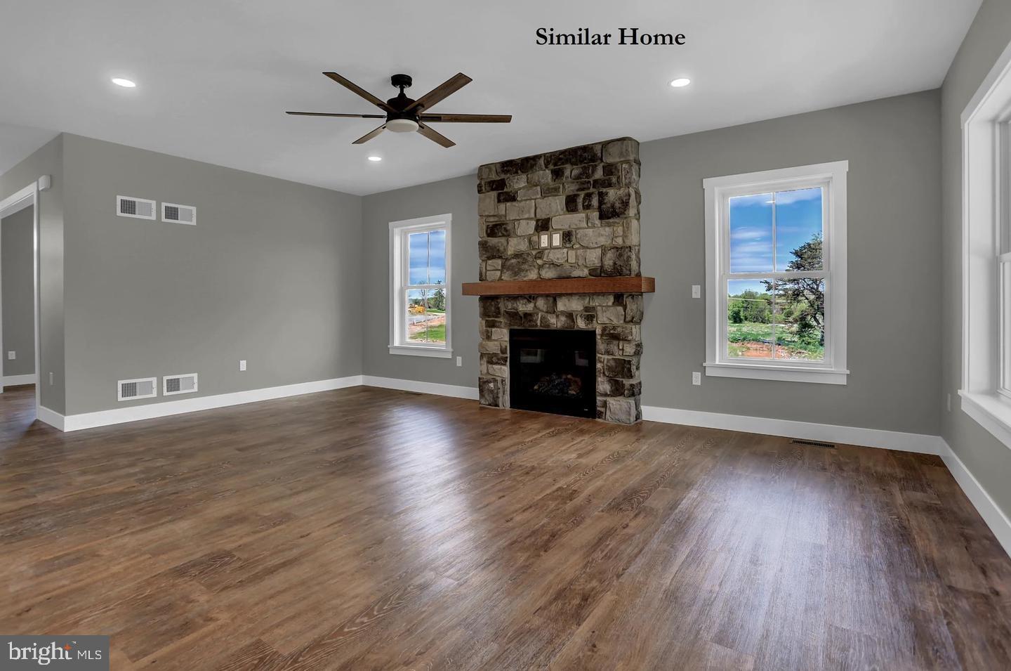 Hill Road, Unit CAMDEN New Freedom, PA 17349 - Photo 12 of 52 an empty room with windows a fireplace a ceiling fan and wooden floor