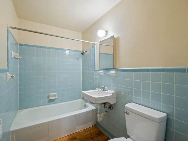 a bathroom with a sink a toilet a mirror and bathtub