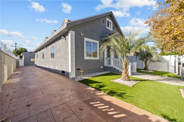 a view of a white house next to a yard and trees