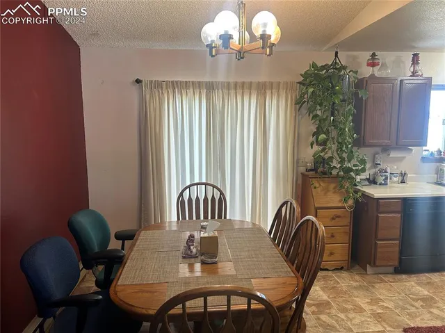 a view of a dining room with furniture and chandelier