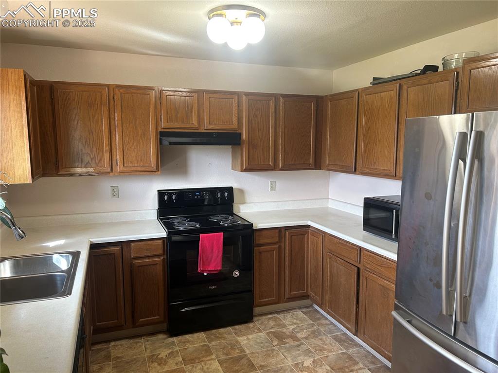 15840 Teak Place Elbert, CO 80106 - Photo 18 of 32 a kitchen with stainless steel appliances a stove a refrigerator and a sink