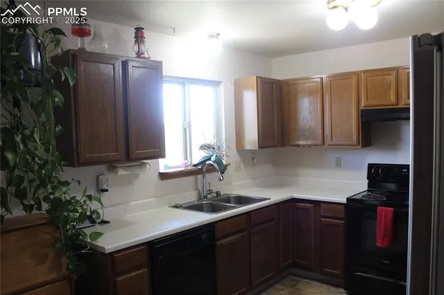 a kitchen with kitchen island granite countertop a refrigerator stove top oven and sink