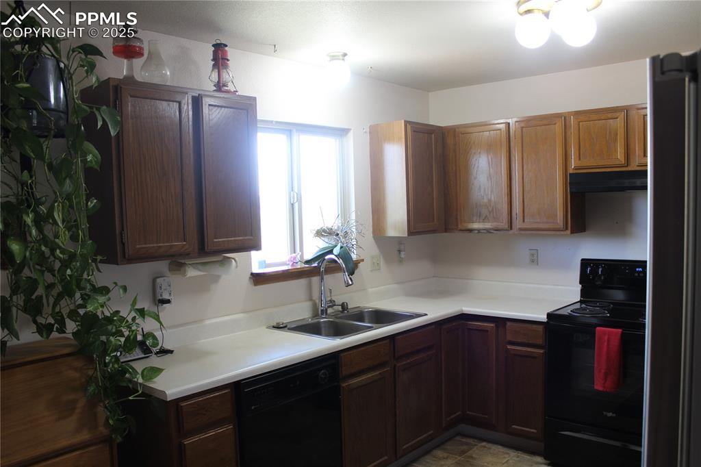 15840 Teak Place Elbert, CO 80106 - Photo 19 of 32 a kitchen with stainless steel appliances granite countertop a sink dishwasher stove and cabinets with wooden floor