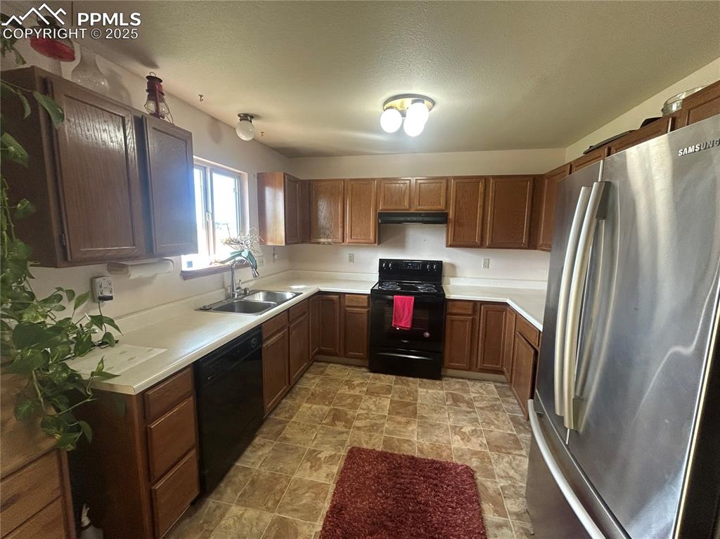 15840 Teak Place Elbert, CO 80106 - Photo 20 of 32 a kitchen with kitchen island granite countertop a refrigerator stove top oven and sink