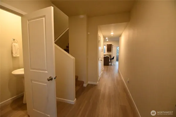 a view of a hallway with wooden floor and staircase