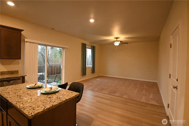 a kitchen with a sink a counter top space and living room filled with furniture