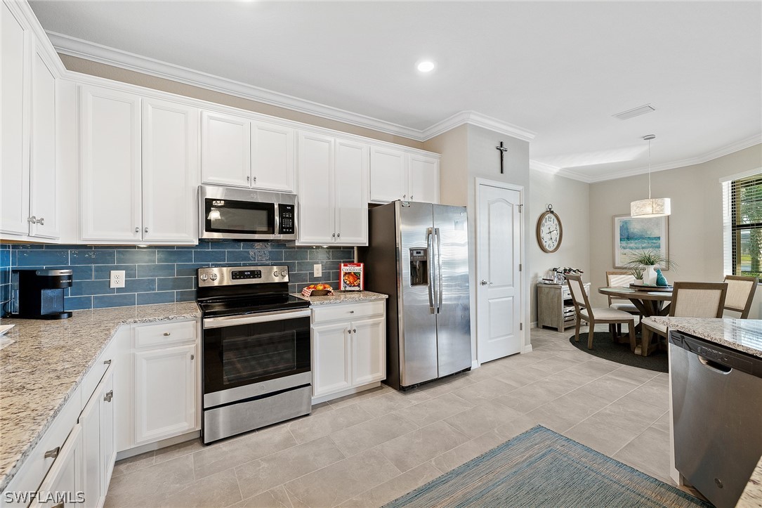 19729 Beechcrest Place Estero, FL 33928 - Photo 12 of 45 a kitchen with refrigerator a sink and a stove