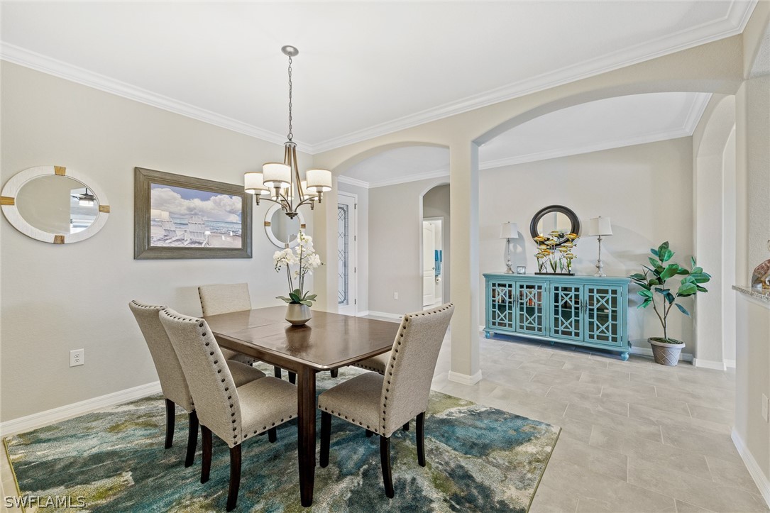 19729 Beechcrest Place Estero, FL 33928 - Photo 15 of 45 a dining room with furniture a window and a chandelier