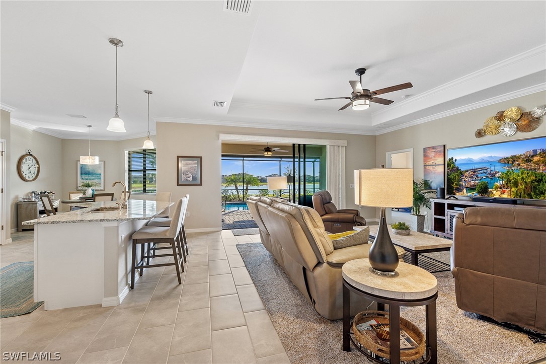 19729 Beechcrest Place Estero, FL 33928 - Photo 8 of 45 a living room with furniture a chandelier and a dining table