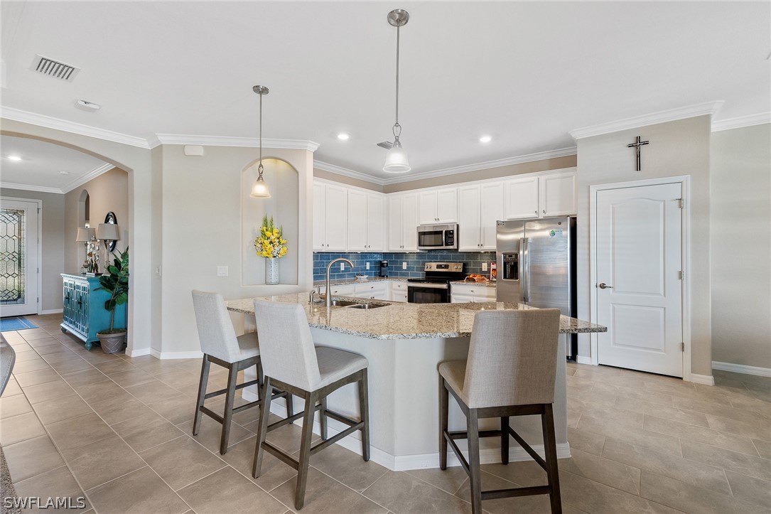19729 Beechcrest Place Estero, FL 33928 - Photo 9 of 45 a view of kitchen with refrigerator a dining table and chairs