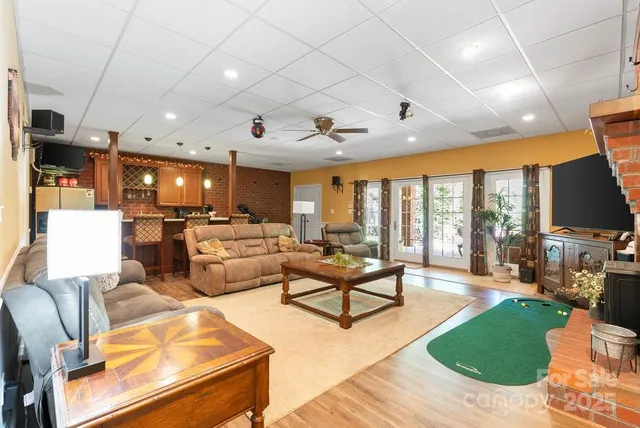 a living room with furniture kitchen view and a large window