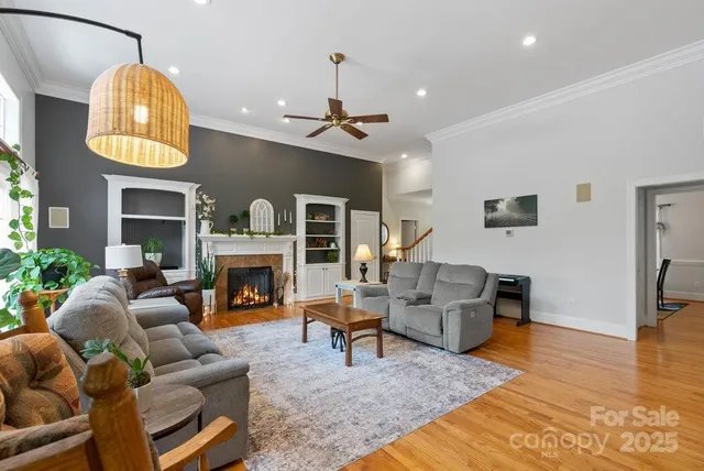 a living room with furniture a fireplace and a chandelier