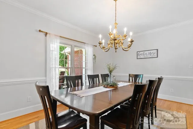 a view of a dining room with furniture a chandelier and wooden floor