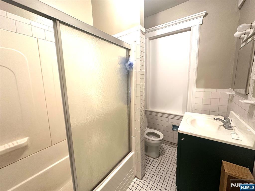 218 Main Street Ridgefield Park, NJ 07660 - Photo 7 of 8 a bathroom with a sink a toilet and shower